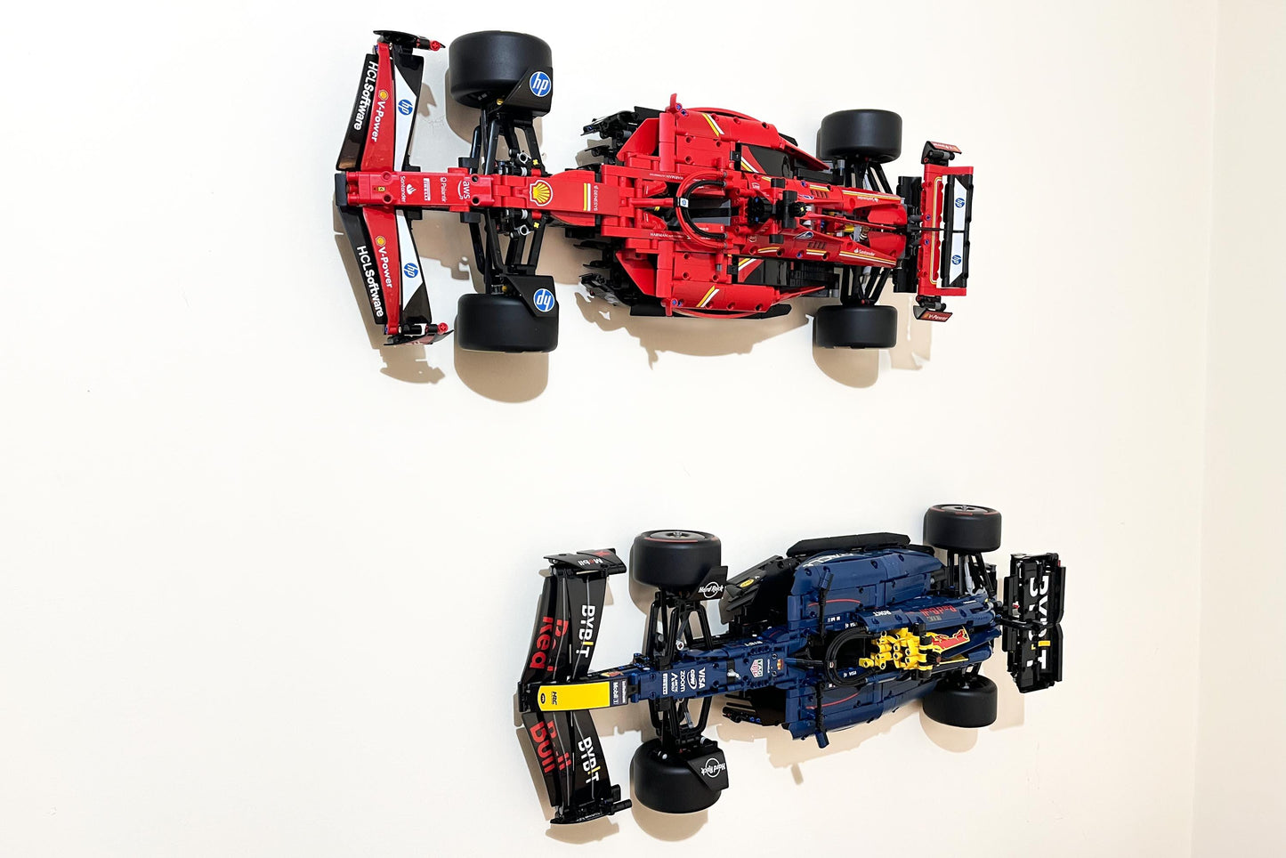 Left isometric view  of the LEGO Technic Ferrari SF-24 F1 car (set 42207) wall mounted with the LEGO Technic Red Bull Racing Formula One car