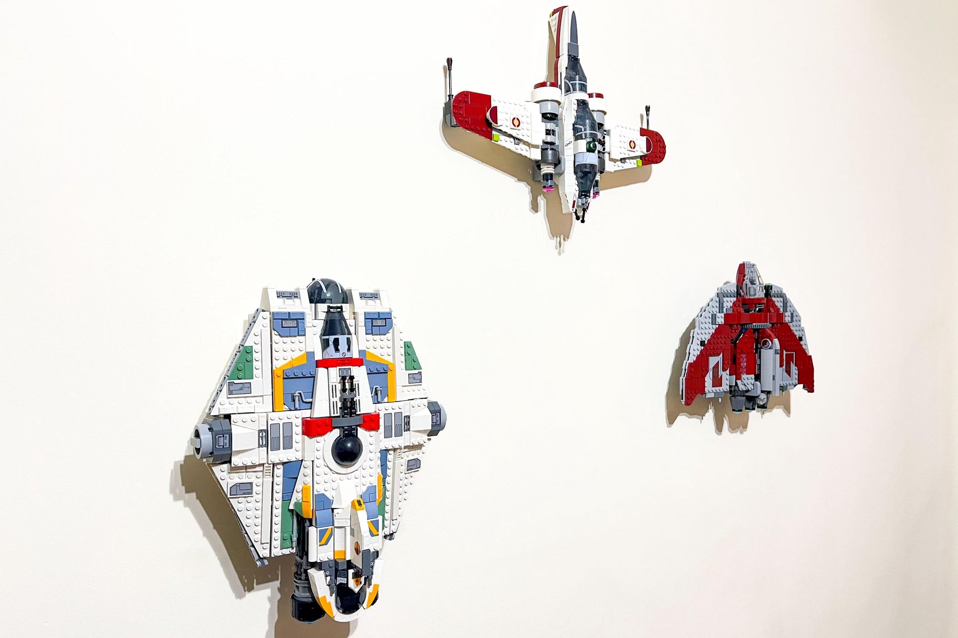 Isometric view of LEGO Star Wars ARC-170 Starfighter (set 75402) displayed with Ahsoka's Jedi shuttle and the Ghost spaceship, all wall-mounted using 3Dudes & Dad display brackets.