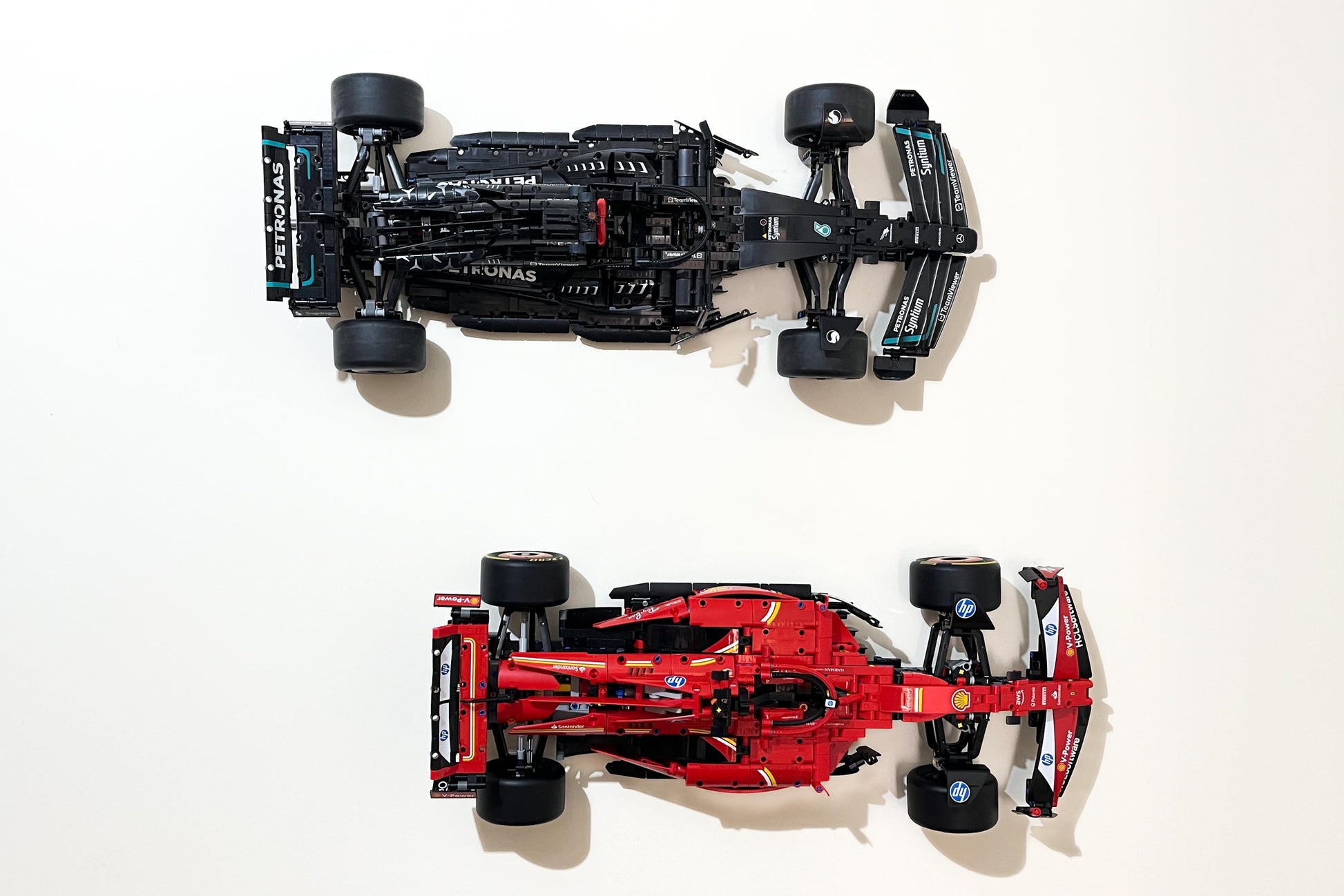 Front view  of the LEGO Technic Ferrari SF-24 F1 car (set 42207) wall mounted with the LEGO Technic Mercedes AMG Formula One car